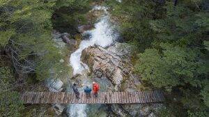 People standing on a bridge over the rapids of Patagonia